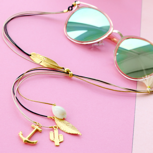 Zomer proof: zonnebrilkoorden met gouden details en minimalistische oorbellen