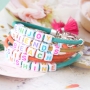 Kleurrijke sieraden en sleutelhangers van DQ leer gepersonaliseerd met letterkralen