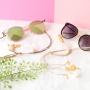 Zomer proof: zonnebrilkoorden met gouden details en minimalistische oorbellen