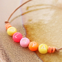 Een vrolijke sieraden set met letterkralen, fimo bedels, houten kralen en Katsuki kralen